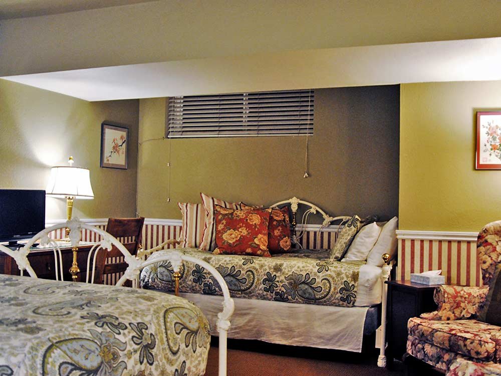 two white wrought iron beds with pillows